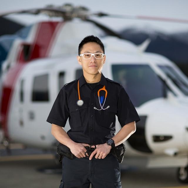 An air ambulance technician stands near a helicopter
