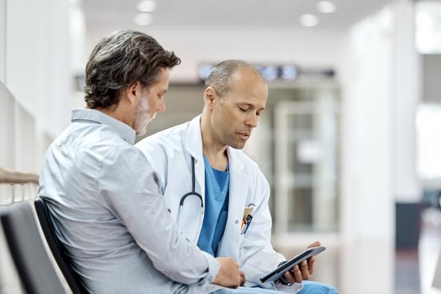 A doctor speaks with an adult parent or caregiver