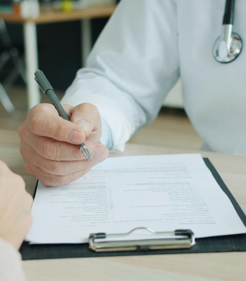 Doctor writing on a clipboard